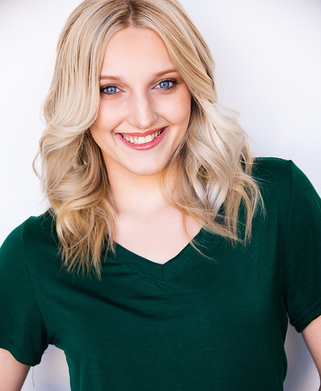 Caitlin Cruz in a green top, smiling against a light background